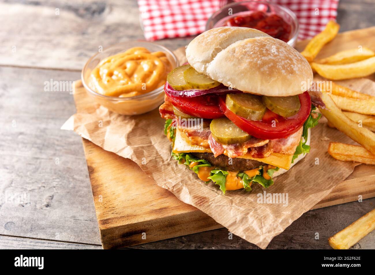 Hamburger di manzo con pancetta su tavolo di legno Foto Stock