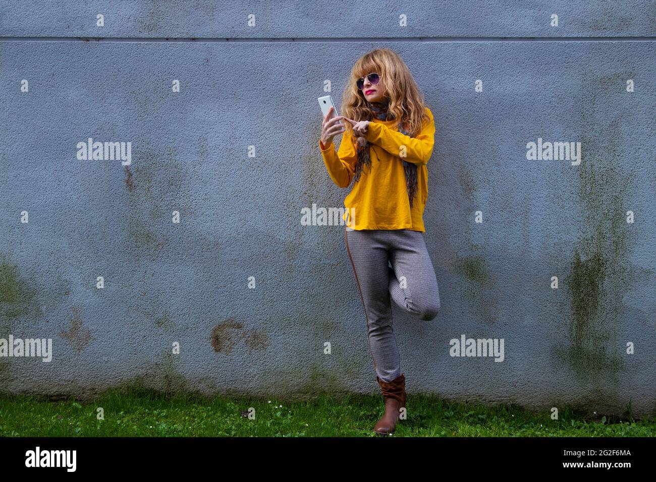 donna che digita il telefono cellulare sulla strada Foto Stock