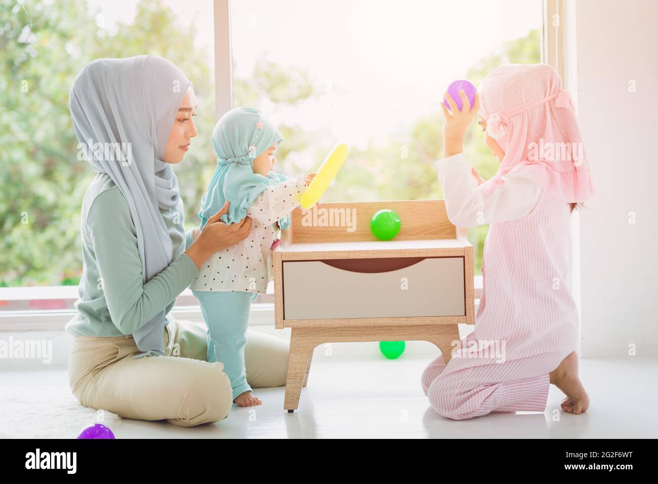 Musulmana famiglia araba madre e i suoi bambini felici di giocare insieme a casa carino e adorabile. Foto Stock