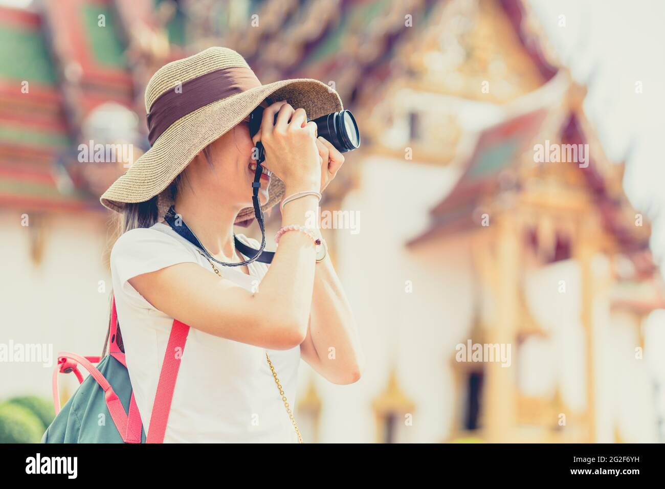 Ragazza teen viaggio in Thailandia. Tourist scatta una foto al tempio in stile di vita di vacanza vintage paese asiatico in vacanza. Foto Stock