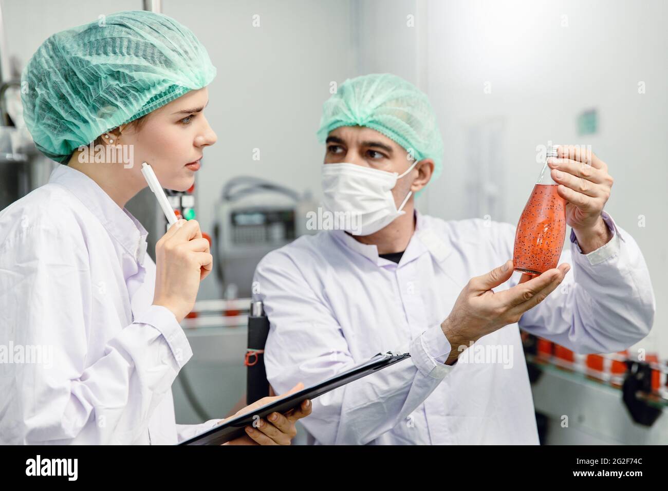 Il team di controllo qualità e sicurezza alimentare verifica lo standard di prodotto nella linea di produzione di fabbriche di alimenti e bevande. Foto Stock