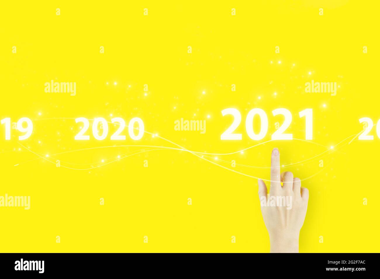 Concetto di carta di nuovo anno aziendale. Mano di giovane donna che punta il dito con ologramma 2021 segno su sfondo giallo Foto Stock