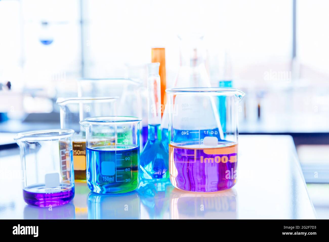 Mix di sostanze chimiche colorate in fiasca di vetreria scientifica presso il laboratorio di scienza. Bello sfondo di laboratorio di chimica. Foto Stock