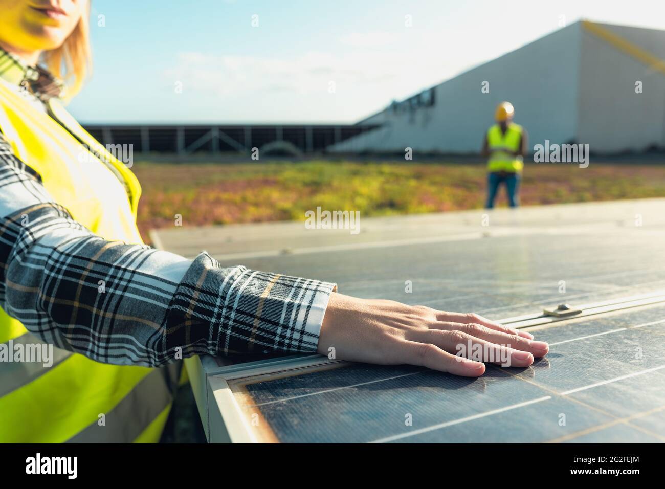 Giovane ingegnere femminile che lavora per l'energia alternativa con turbina eolica E pannelli solari fotovoltaici - innovazione e concetto di energia verde Foto Stock