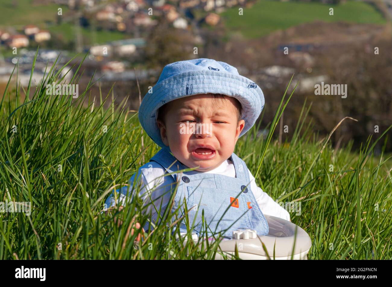 Bambino asiatico in un cappello piangendo nel pugnale Foto Stock