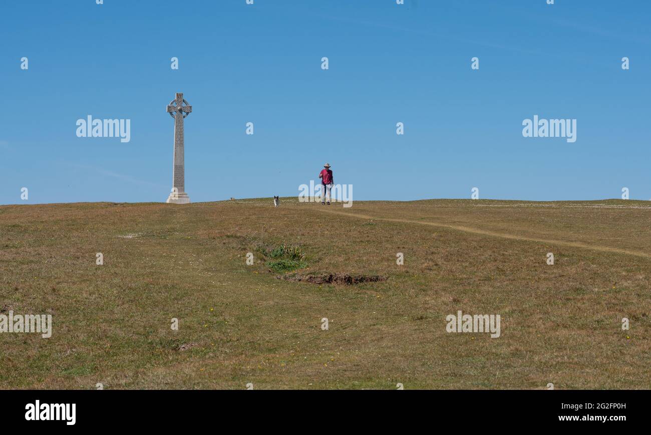 Un uomo ed il suo cane camminano giù dal Tennyson Memorial Cross su Tennyson giù sull'isola di Wight Hampshire Regno Unito Foto Stock