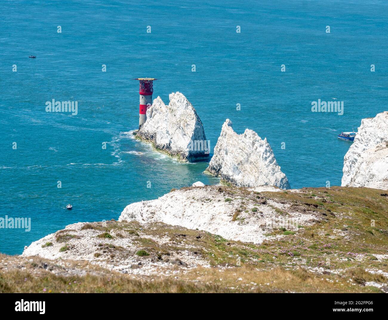 Gli aghi pile di gesso e il faro degli aghi che sorvegliano il Solent nel punto occidentale dell'Isola di Wight UK Foto Stock