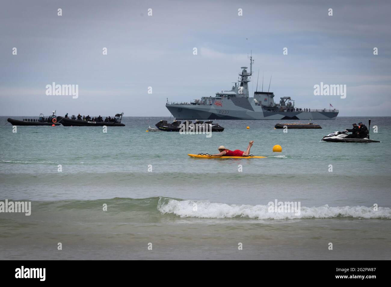 St Ives, Regno Unito. 11 Giugno 2021. Un paddle boarder passa accanto alla Royal Navy, che è stata schierata per il G7 Summit. Credit: Andy Barton/Alamy Live News Foto Stock