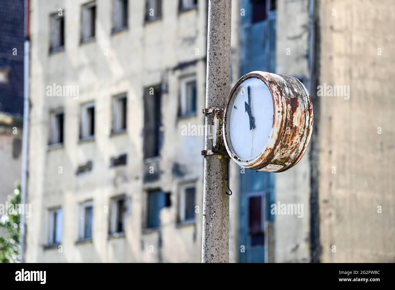 Pasewalk, Germania. 10 Giugno 2021. Un orologio intemperie sul sito di un'ex impresa agricola della RDT di fronte a un edificio in via di dilatazione. Fino alla caduta del Muro, questo fu il sito di un impianto di miscelazione concentrato del VEB Getreidewirtschaft Pasewalk. L'orologio si fermò poco prima delle 11. Credit: Jens Kalaene/dpa-Zentralbild/ZB/dpa/Alamy Live News Foto Stock