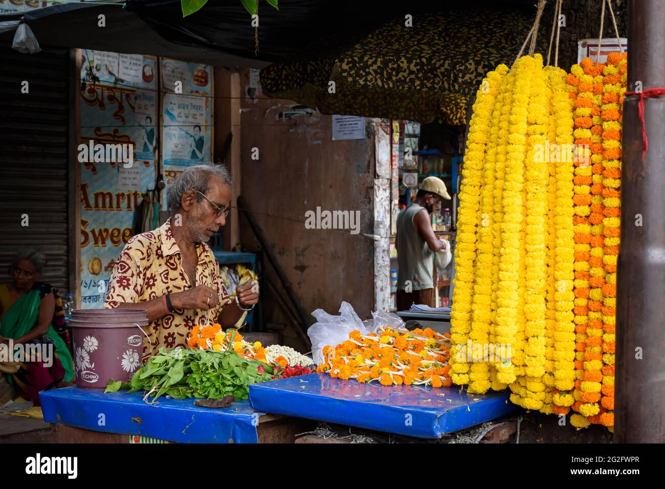 Un venditore indiano non identificato che vende fiori colorati al suo carrello nel mercato locale a Kolkata, India il 2020 ottobre Foto Stock