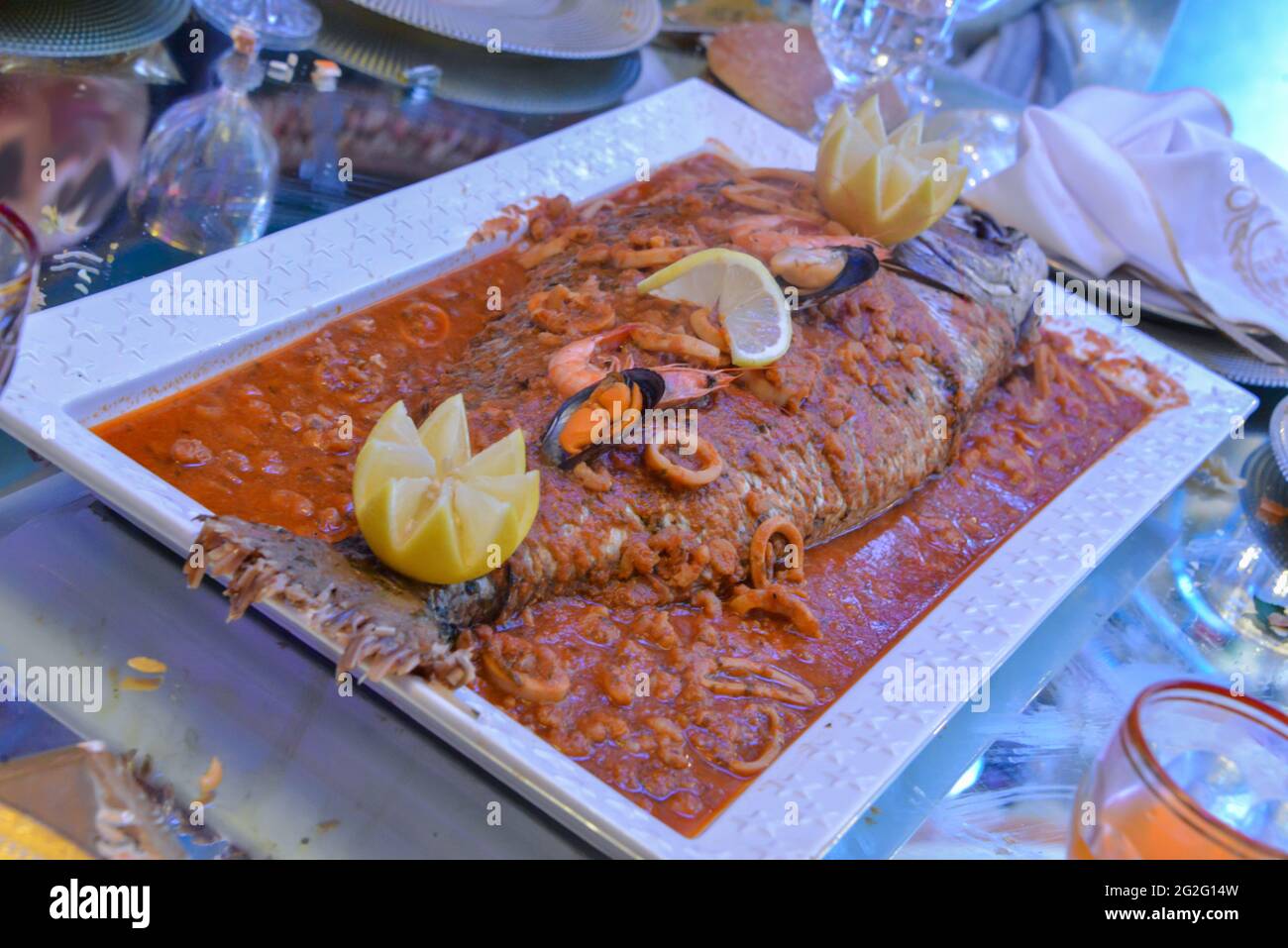 Un grande pesce ripieno di calamari e gamberi, servito al matrimonio Foto Stock