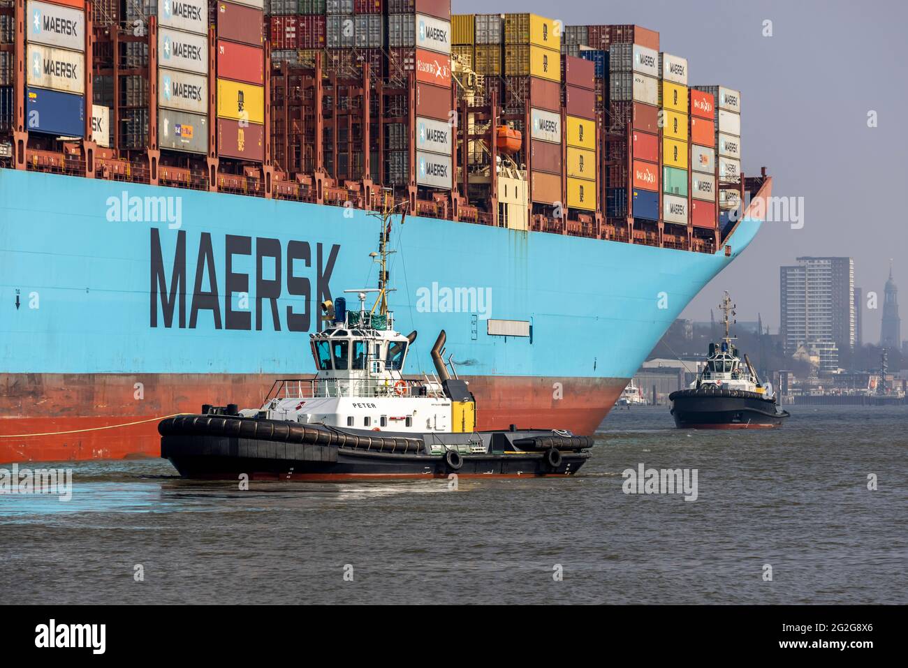La nave-container MARGRETHE MAERSK entra, gira e traina nel porto di Amburgo Foto Stock