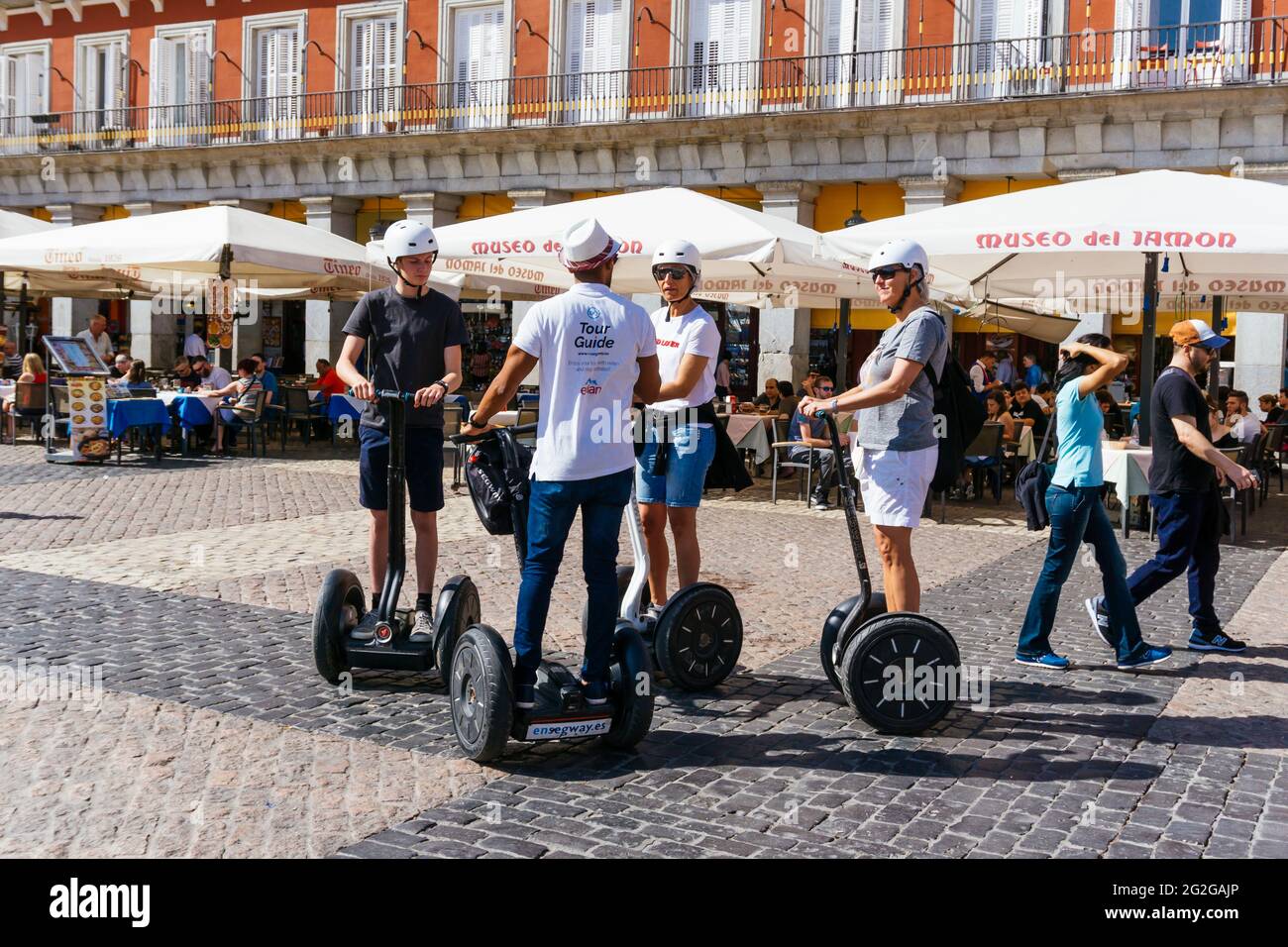 I turisti in un tour della città in Segway. Plaza Mayor, la piazza principale, è uno dei principali spazi pubblici nel cuore di Madrid, la capitale della Spagna. Madrid, Foto Stock