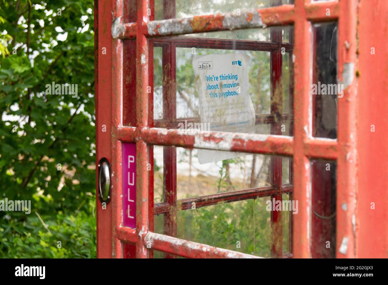 "Stiamo pensando di rimuovere questo telefono a pagamento" all'interno della tradizionale scatola telefonica rossa bt, Strachur, Argyll e Bute, Scozia, Regno Unito Foto Stock