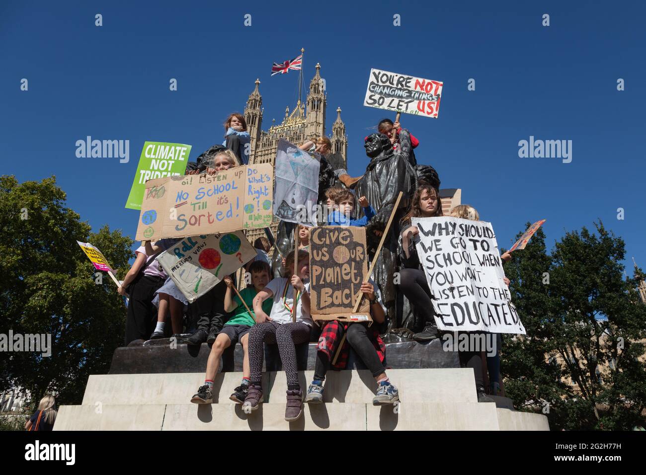 Bambini che protestano contro il cambiamento climatico sulla scultura di Auguste Rodin "i Burghers di Calais" nei Victoria Tower Gardens, Londra. Foto Stock