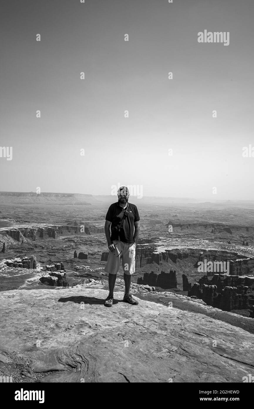 Uomo in piedi al Grand View Point. Escursione panoramica e facile a 2 km circa lungo il bordo della mesa con ampie vedute del suggestivo terreno del canyon nel Canyonlands National Park, Utah, USA Foto Stock