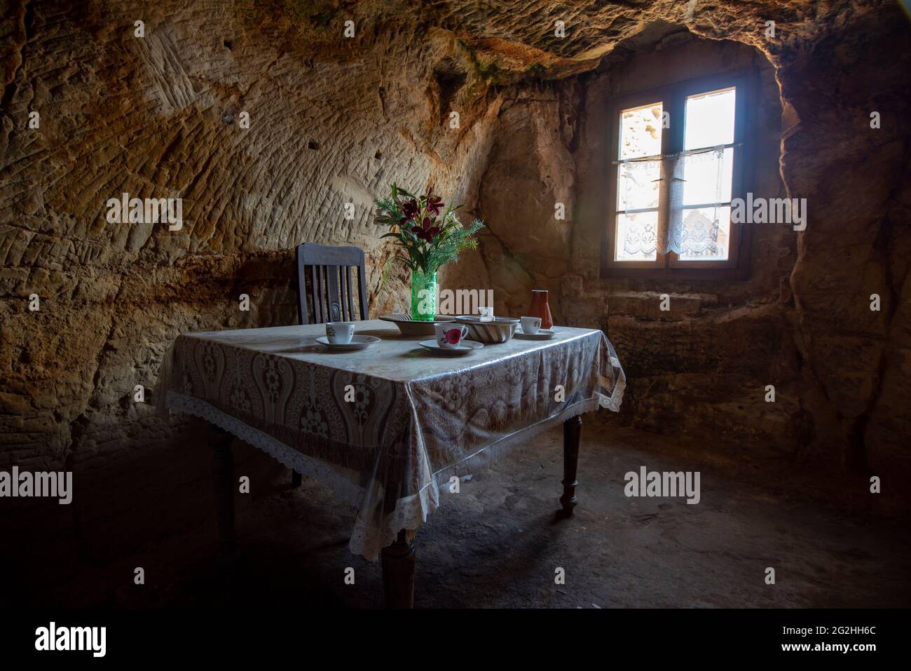 Germania, Sassonia-Anhalt, Langenstein, ha posato il tavolo in una delle abitazioni rupestri di Langenstein, scolpito in arenaria da lavoratori migranti nel 19 ° secolo, ora accessibile ai visitatori, Harz. Foto Stock