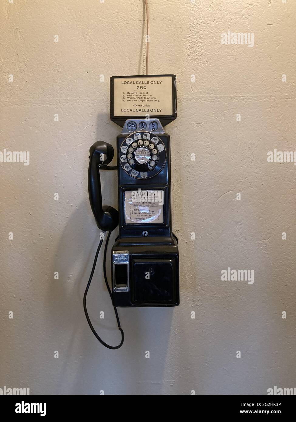 telefono a pagamento rotante su una parete Foto Stock
