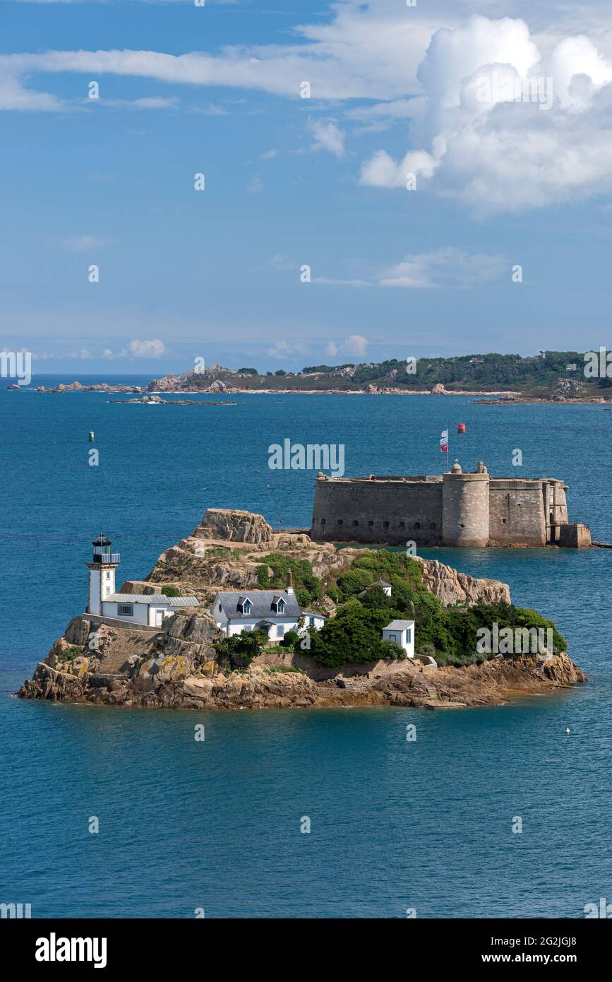 Ile Louët con faro e casa del custode, sullo sfondo Château Taureau, vicino a Carantec nella baia di Morlaix, Francia, Bretagna, dipartimento del Finistère Foto Stock