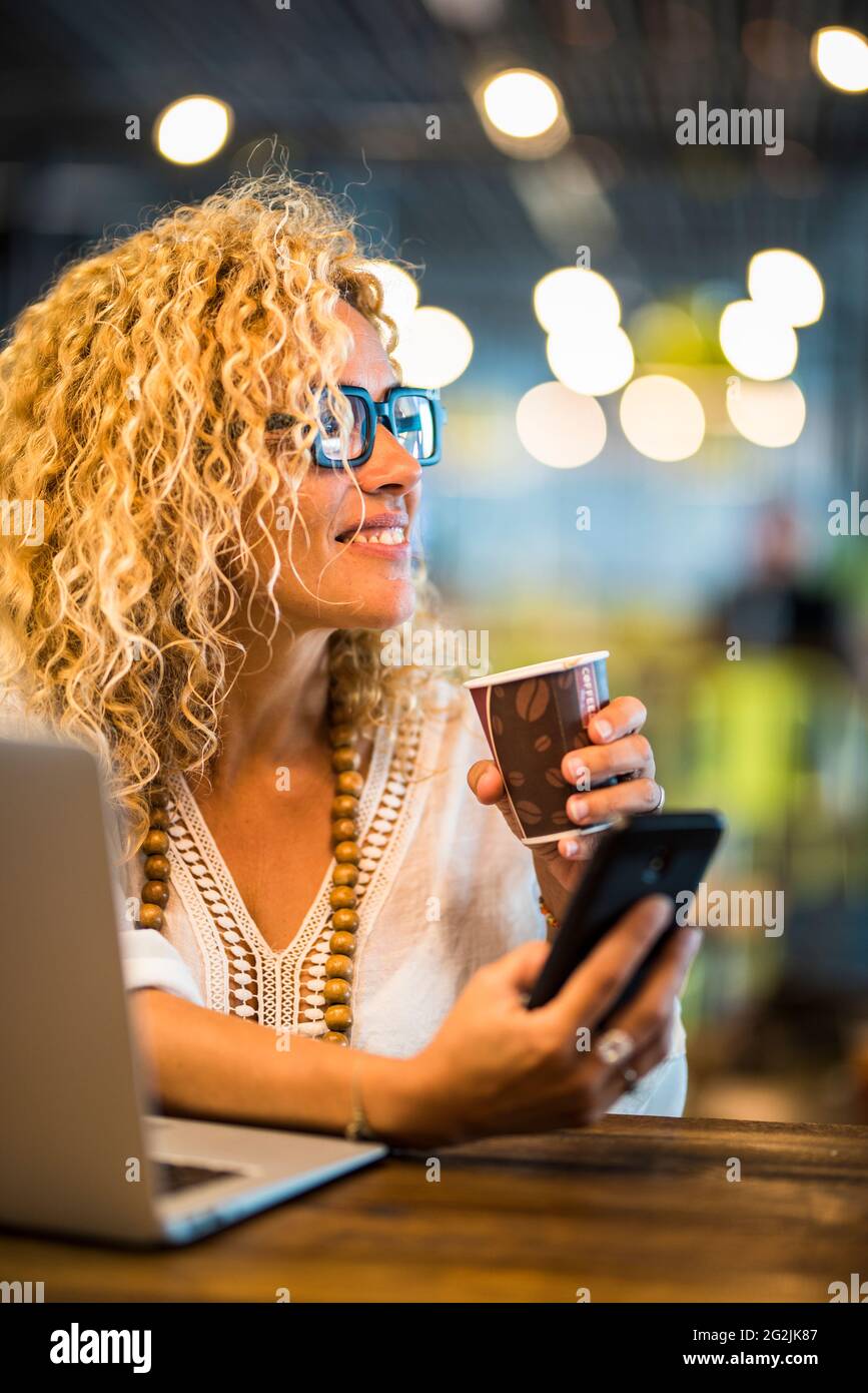 Lavoro di viaggio e stile di vita di concetto di lavoro intelligente con giovane adulto bella donna utilizzare telefono e computer laptop con connessione roaming e wifi gratuito aeroporto cancello bar caffè Foto Stock