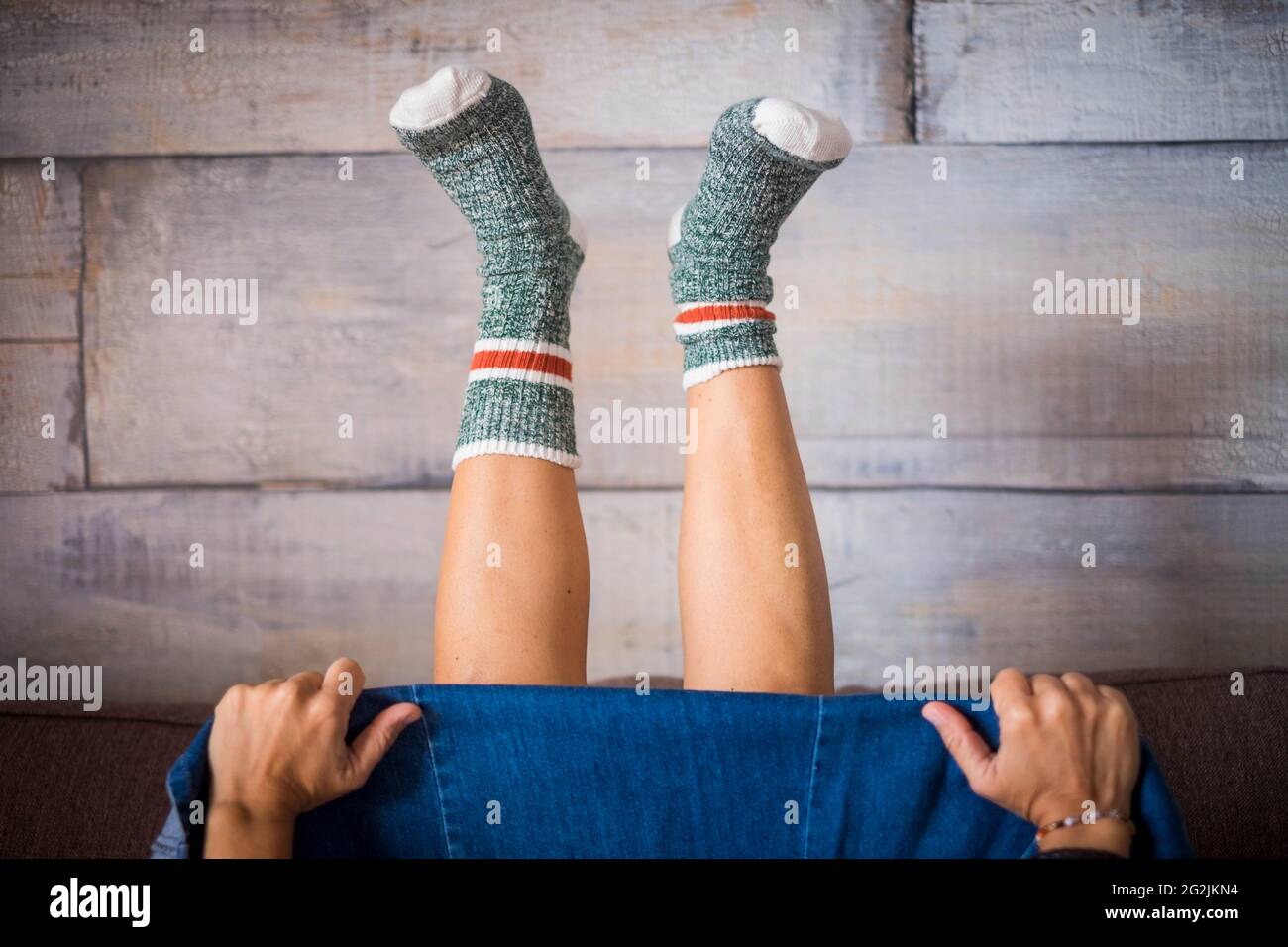 Coppia di gambe donna con calze calde a casa in posizione inversa. Concetto di felicità e malattia di quarantena per le sole donne - Foto Stock