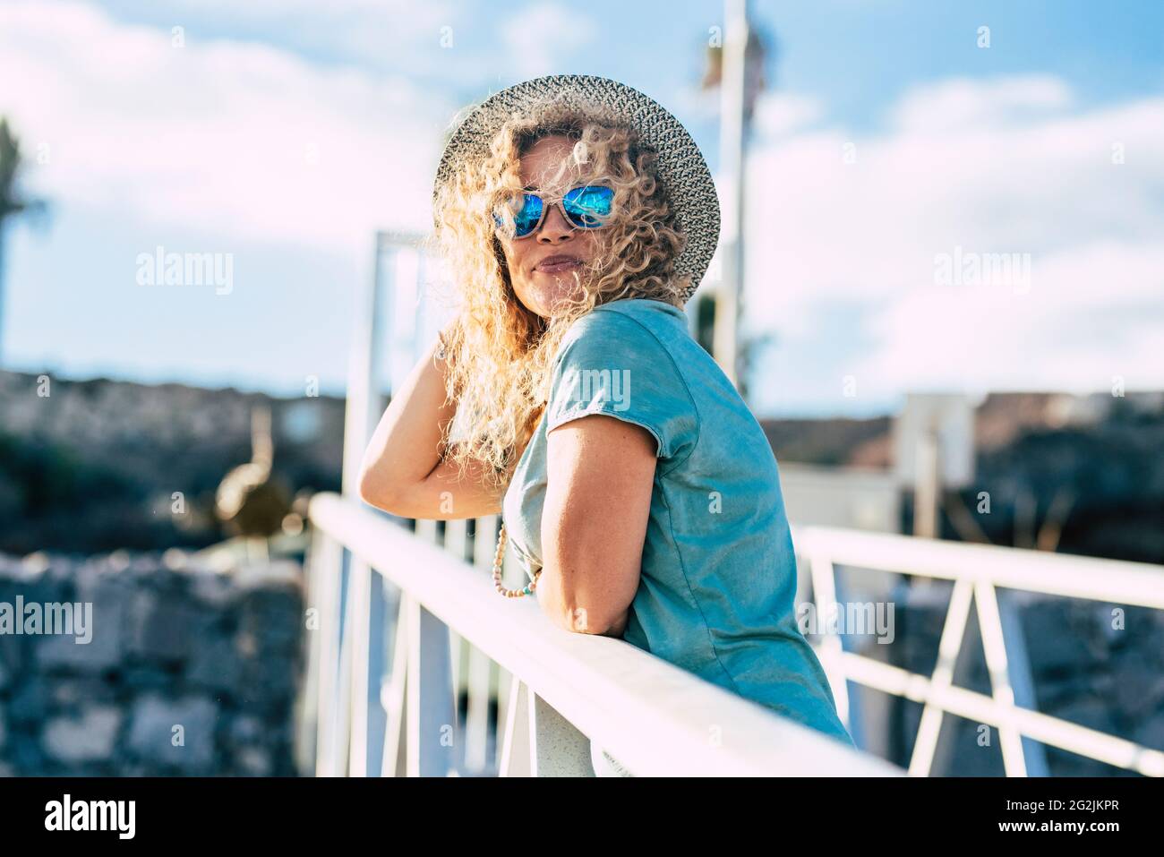 Bella giovane donna adulta sorridere e godere di attività di svago all'aperto in giornata di sole - media età donne persone caucasiche con cappello alla moda - bello gioioso concetto di stile di vita Foto Stock