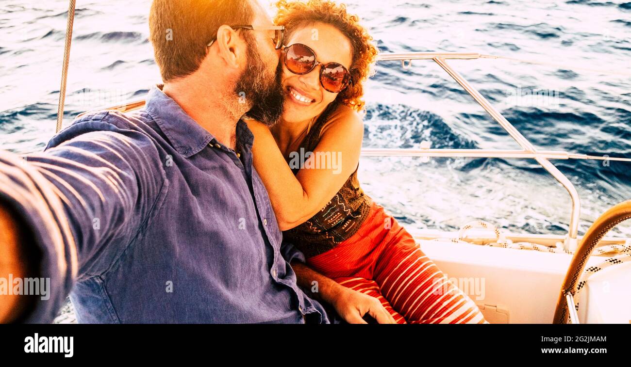 Selfie foto con gioiosa coppia baciare e divertirsi insieme in tour escursione in barca - concetto di persone in amore e vacanza turistica - mare blu acqua in background Foto Stock