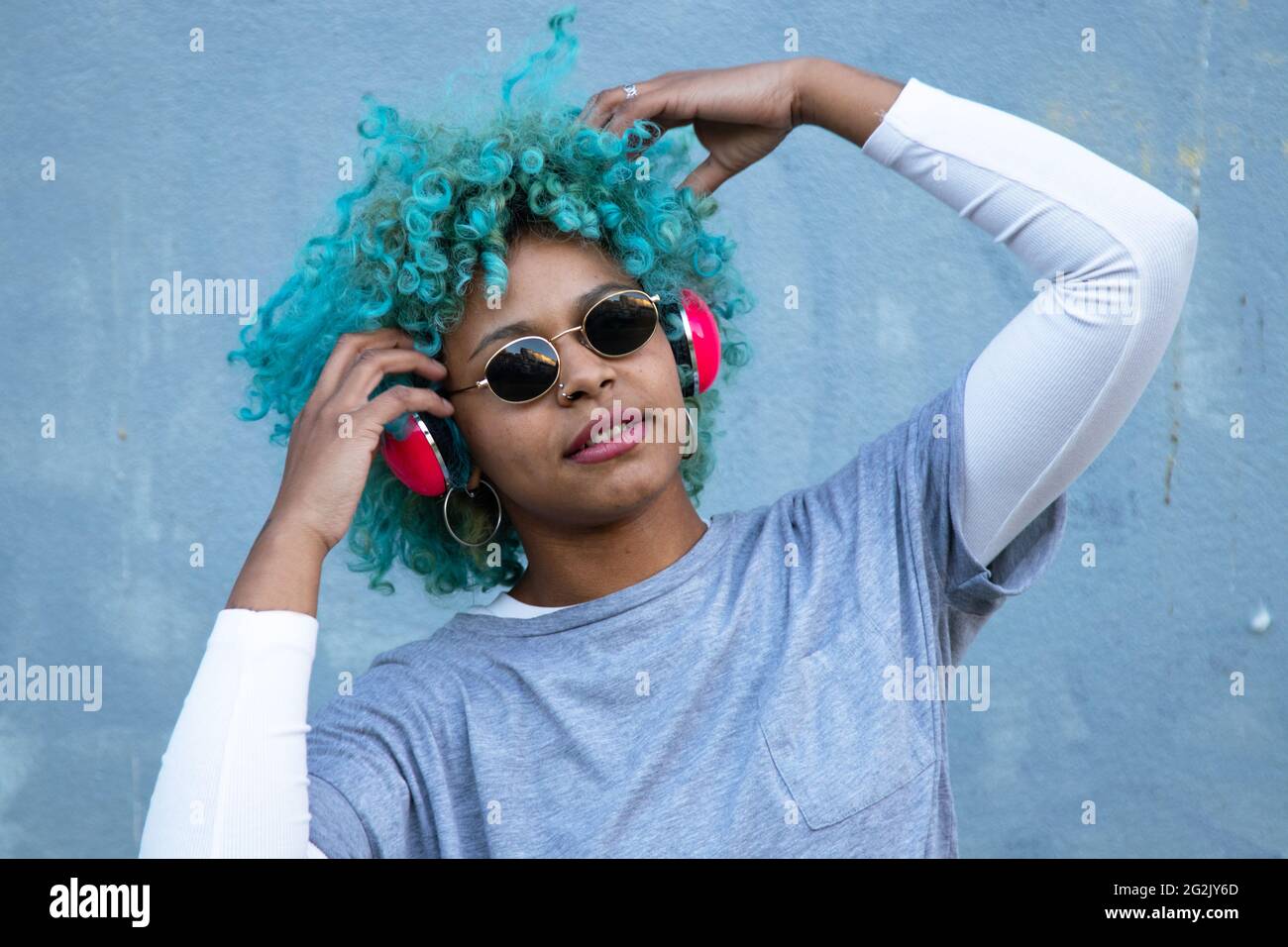 donna afro americana nera con cuffie per strada sorridente felice Foto Stock