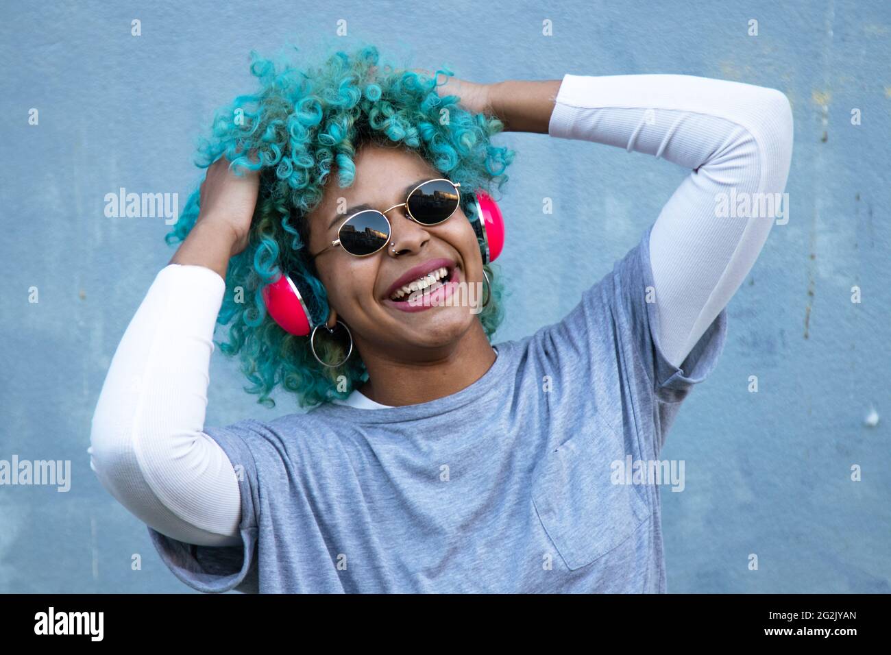 donna afro americana nera con cuffie per strada sorridente felice Foto Stock