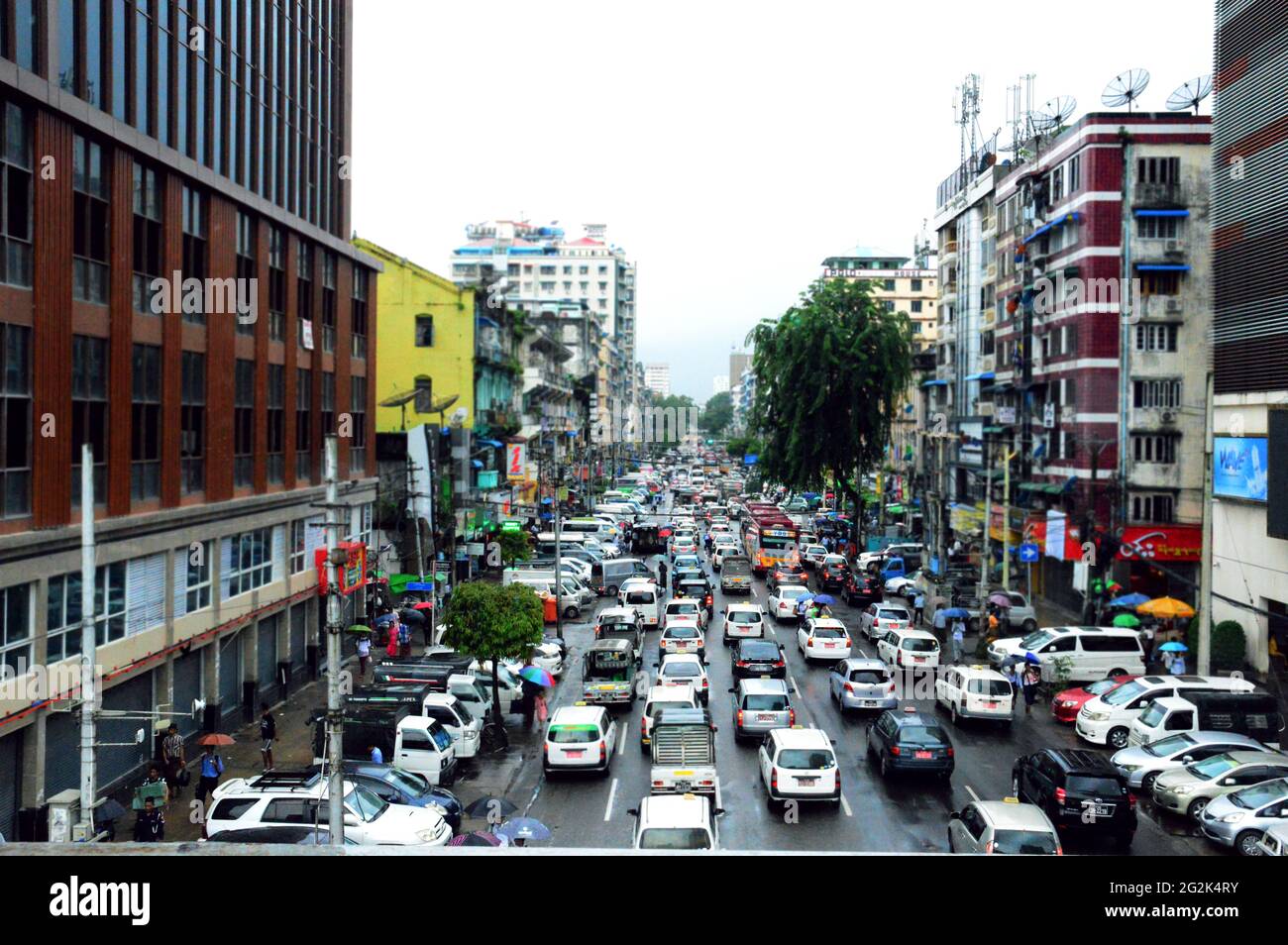 Una strada trafficata di traffico pesante di Yangon, la capitale del Myanmar. La vita prima che il colpo di stato militare si impossessò del controllo. Foto Stock