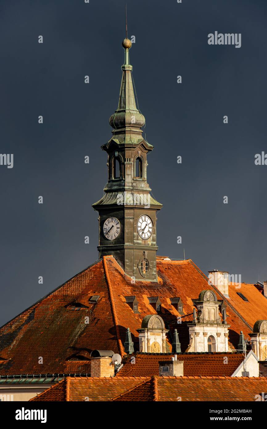 Cielo scuro con nuvole di pioggia sulla città storica con un orologio a torre. Foto Stock