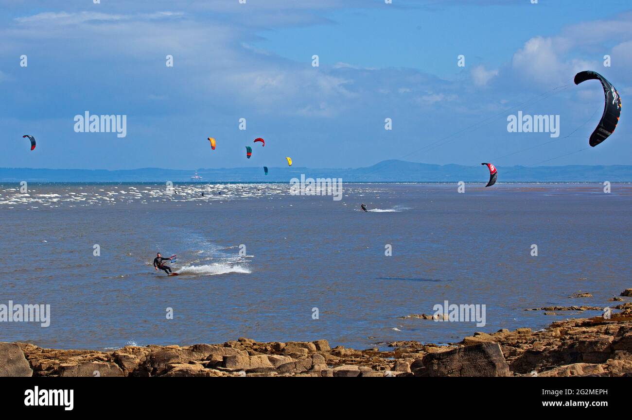Longniddry, East Lothian, Scozia, Regno Unito. 12 giugno 2021. Vento 24 km/h potenziali raffiche 35 km/h con sole e nuvole che sembrava essere il tempo perfetto per più di 20 Kite Surfers che hanno dimostrato le loro abilità sul Firth of Forth. Foto Stock