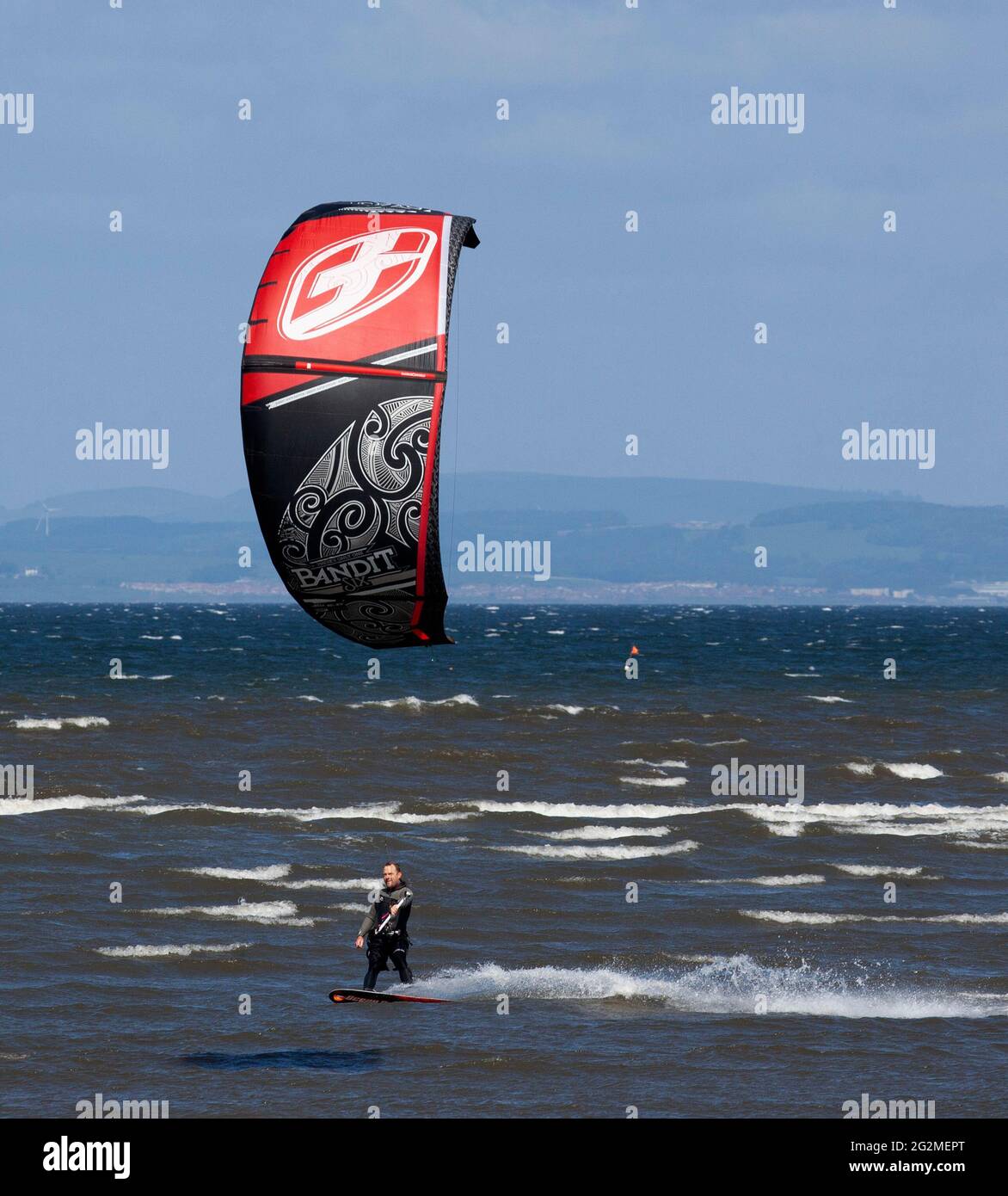 Longniddry, East Lothian, Scozia, Regno Unito. 12 giugno 2021. Vento 24 km/h potenziali raffiche 35 km/h con sole e nuvole che sembrava essere il tempo perfetto per più di 20 Kite Surfers che hanno dimostrato le loro abilità sul Firth of Forth. Foto Stock