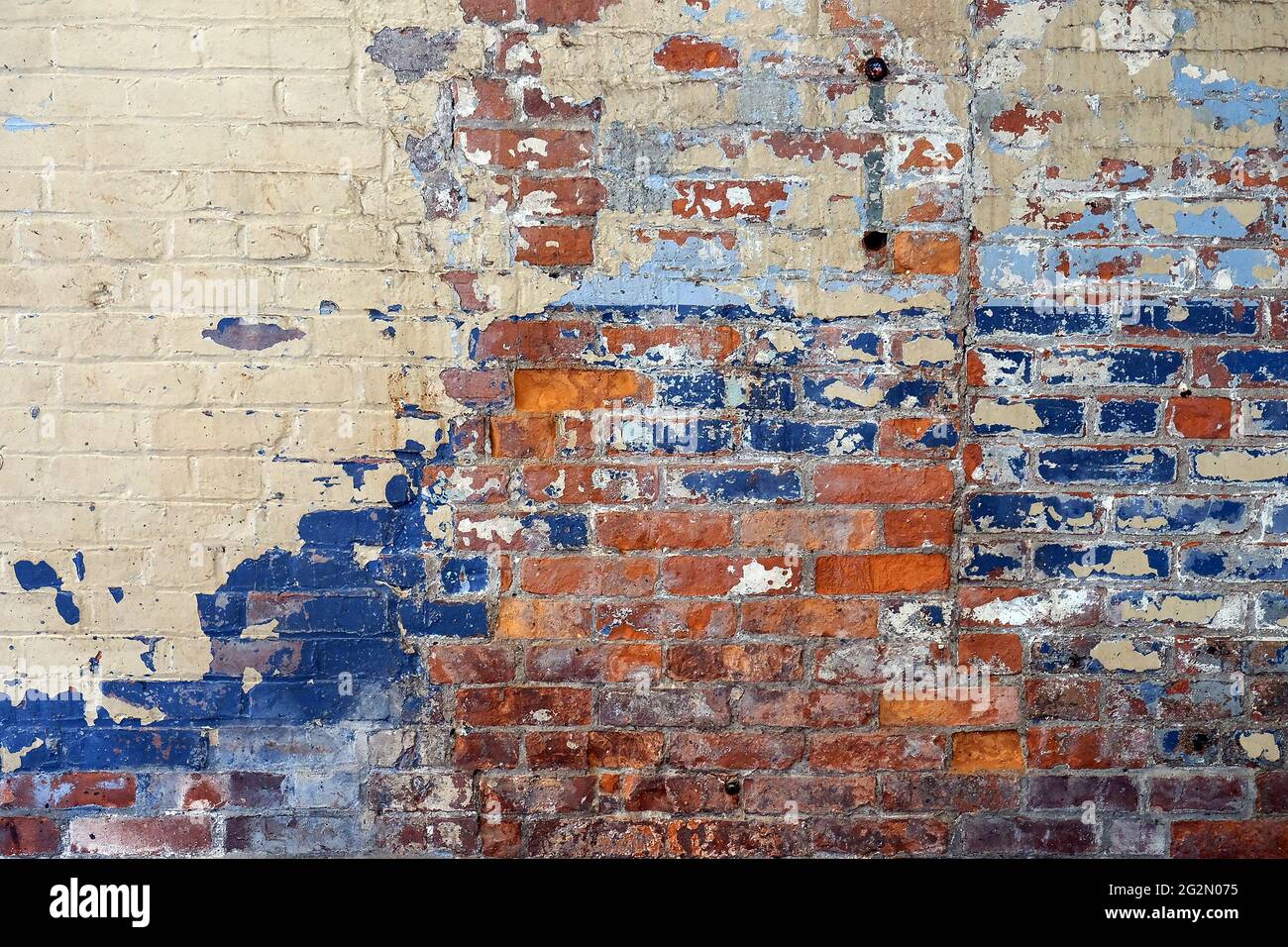 Una parete di mattoni dipinta in più colori Foto Stock
