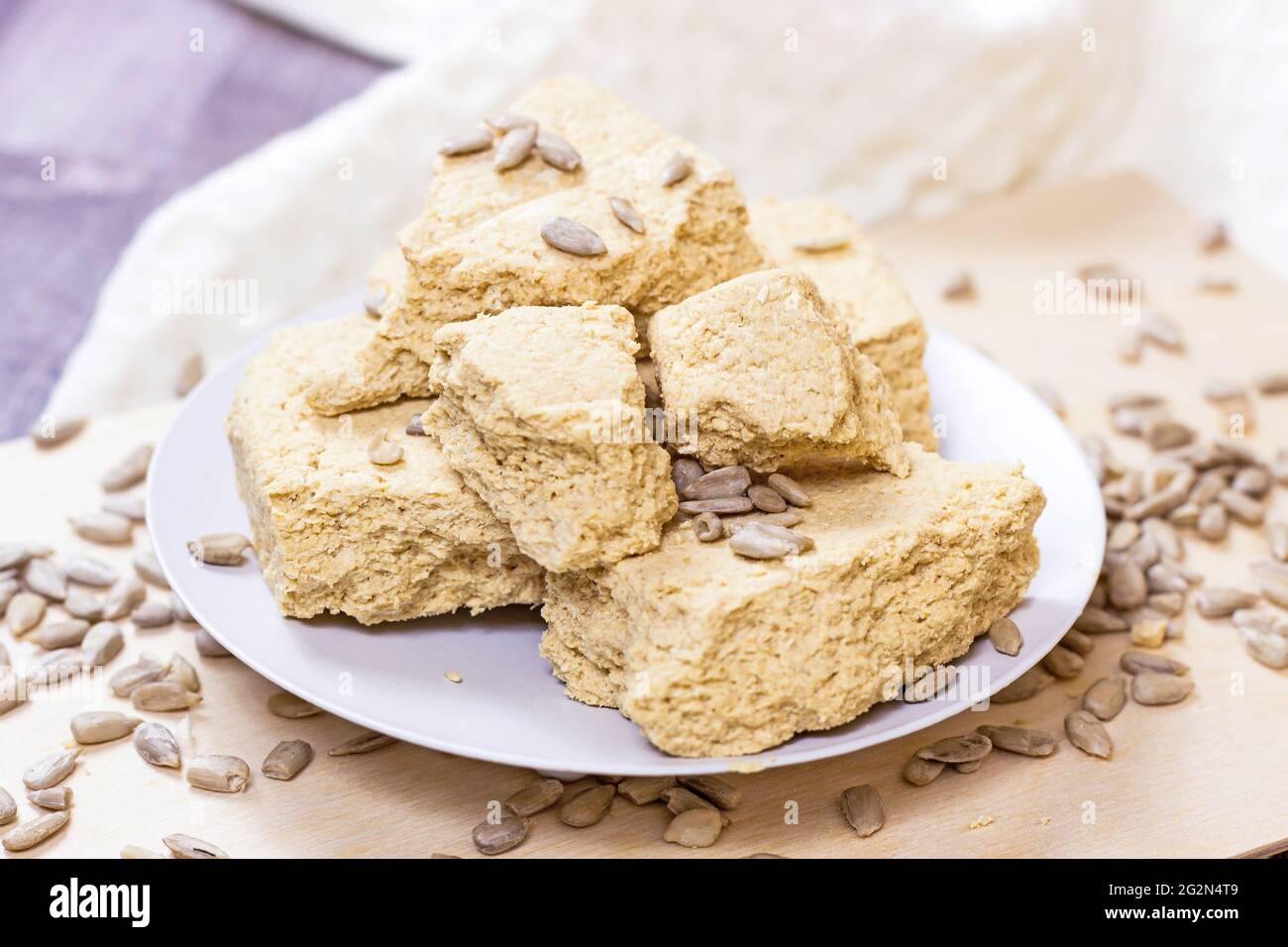 Tradizionali pezzi di halva dolce turco delizia con semi di girasole su sfondo chiaro. Foto Stock