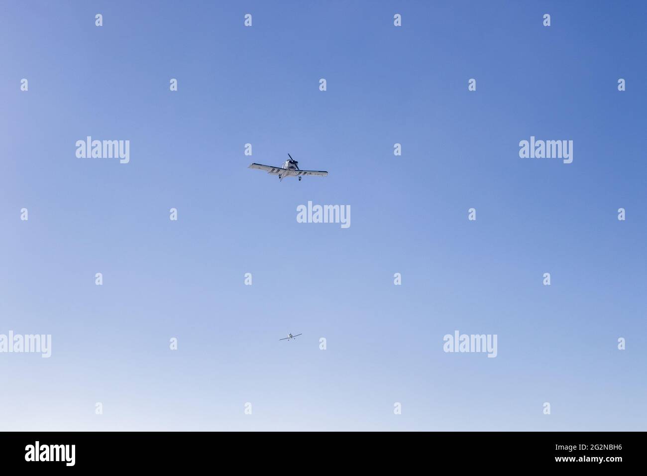 "Volare attraverso i cieli limpidi: Due aerei navigano nella vasta distesa blu, incarnando la libertà e l'avventura del volo in una serena danza aerea." Foto Stock