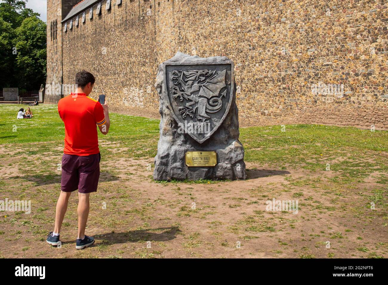Un appassionato di calcio gallese fotografa la cresta di calcio del drago gallese fuori dal castello di Cardiff durante Euro 2020, giugno 2021. Foto Stock Un appassionato di calcio gallese fotografa la cresta di calcio del drago gallese fuori dal castello di Cardiff durante Euro 2020, giugno 2021. Foto Stock