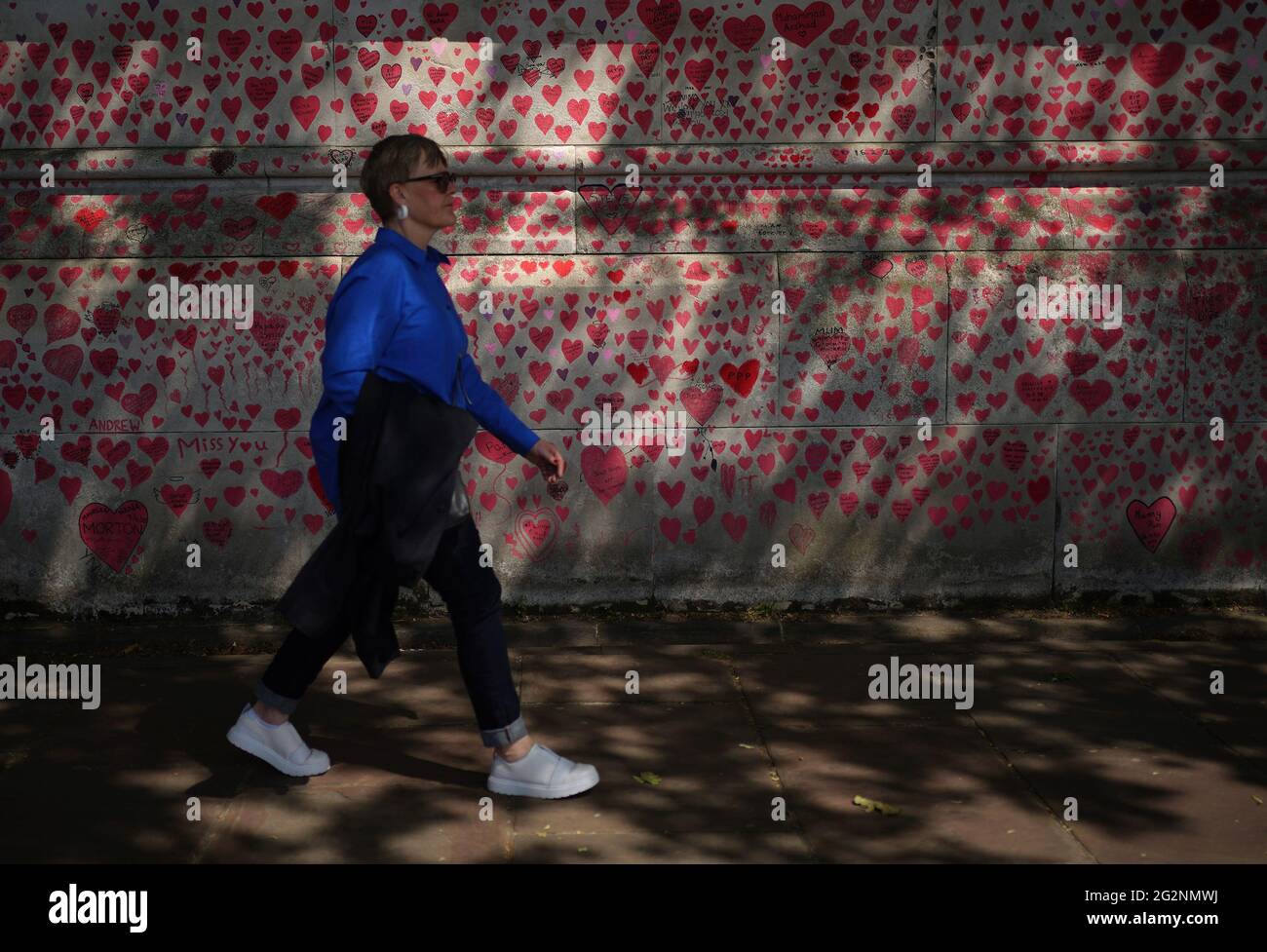 Una donna passa davanti al National Covid Memorial Wall sull'argine di Londra, dopo l'ulteriore allentamento delle restrizioni di blocco in Inghilterra. Data immagine: Sabato 12 giugno 2021. Foto Stock