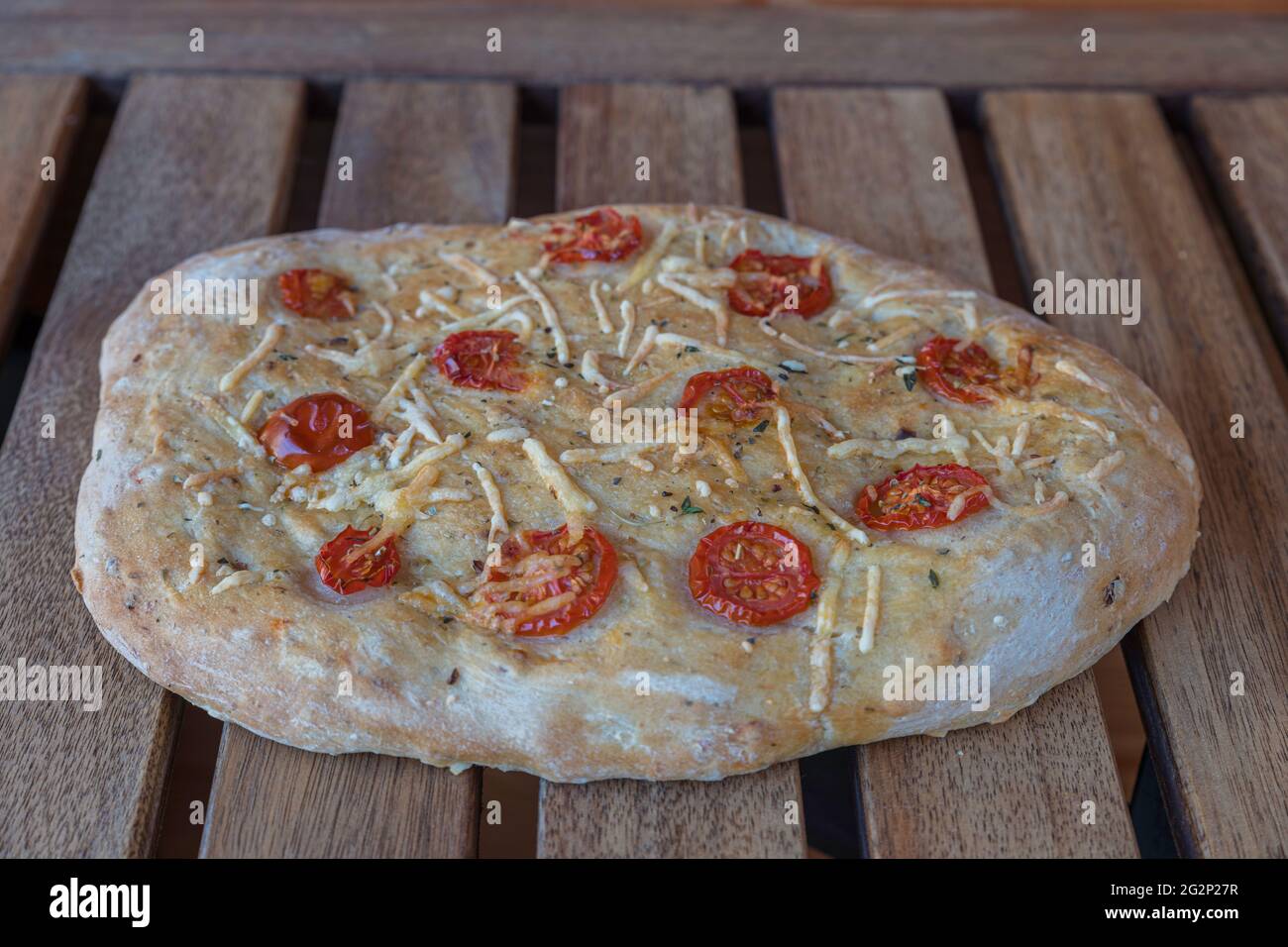 Pane italiano chiamato focacia ripieno con erbe di prosciutto di formaggio e pomodoro Foto Stock