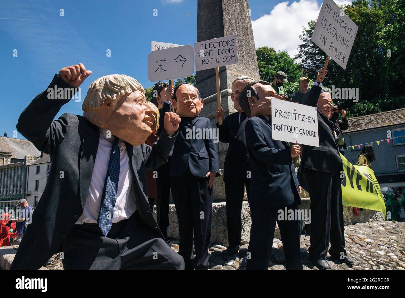 Falmouth, Cornovaglia, Regno Unito 12 giugno 2021 la ribellione per l’estinzione marciò in protesta contro le politiche di ‘lavaggio delle greenwashing’ del governo e degli affari al vertice del G7. I ribelli rossi guidano la marcia attraverso il centro città unendosi ai medici di XR e scrubber sporchi, terminando al centro di media. Foto Stock