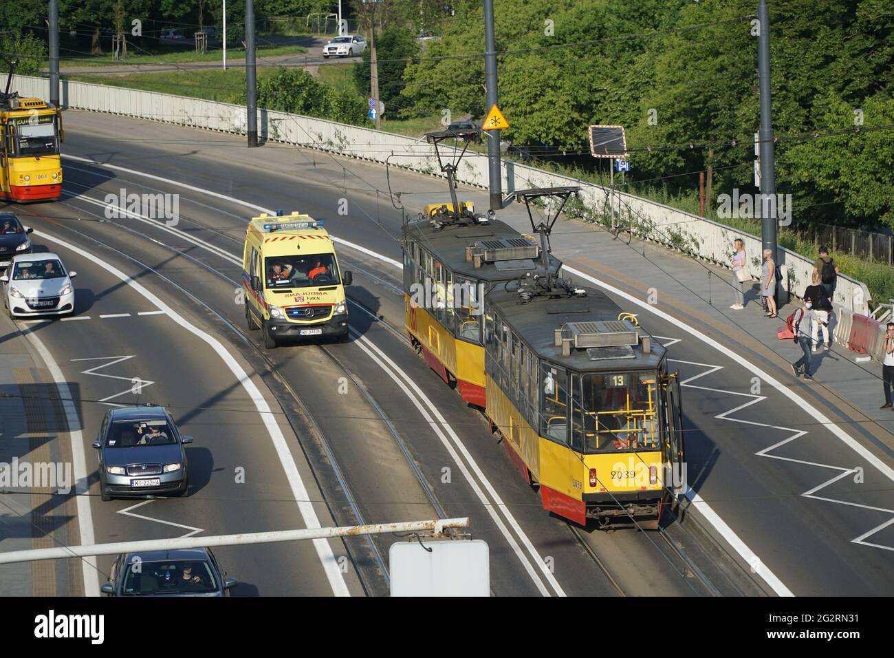 Varsavia, Polonia - 11 giugno 2021: Ambulanza gialla con luci lampeggianti in corsa sulla pista del tram per aggirare l'ingorgo nei pressi della città vecchia di Varsavia. Foto Stock