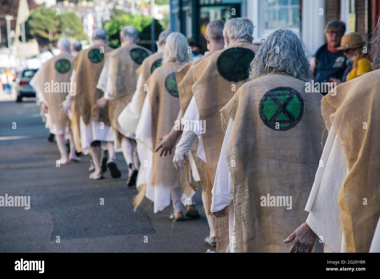 Falmouth, Cornovaglia, Regno Unito 12 giugno 2021 i manifestanti della ribellione estinzione si vestono come 'i penitenti' G7 summit. I penitenti si basano sull'idea medievale di espiazione per le trasgressioni contro la comunità, portano i crimini del mondo contemporaneo in tutto il loro. Foto Stock