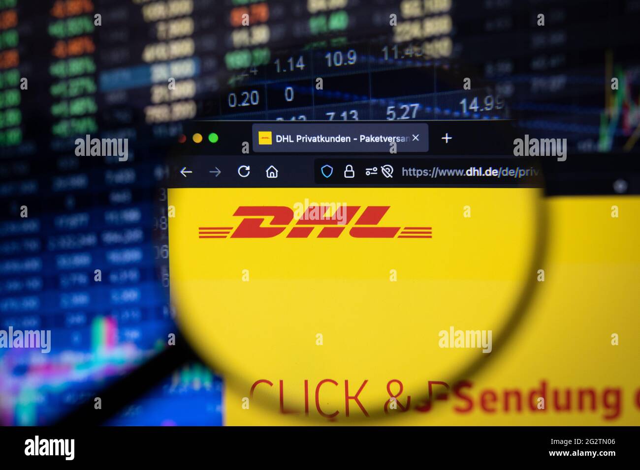 DHL Company logo su un sito web con sviluppi sfocati del mercato azionario sullo sfondo, visto su uno schermo del computer attraverso una lente di ingrandimento Foto Stock