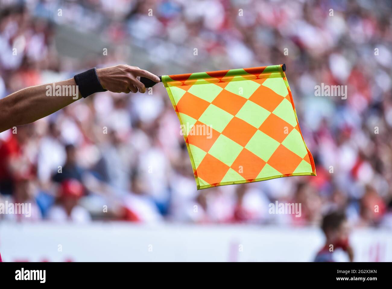 Mano di assistente di arbitro di calcio con bandiera sollevata. Foto Stock