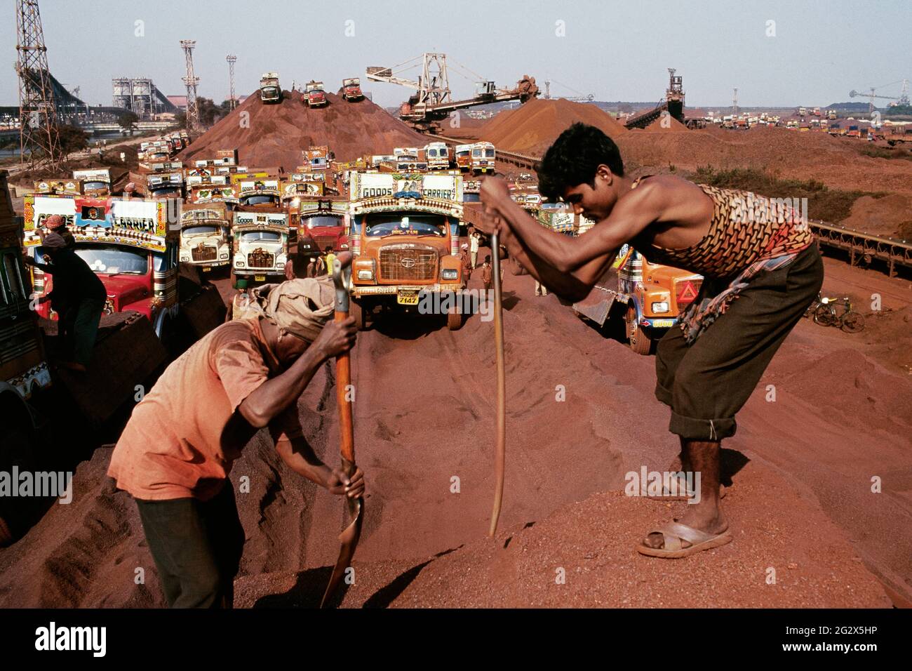 Questi tumuli di minerale di ferro sono legati dall'India alla Cina, da dove ritorneranno come prodotti di acciaio. Foto Stock