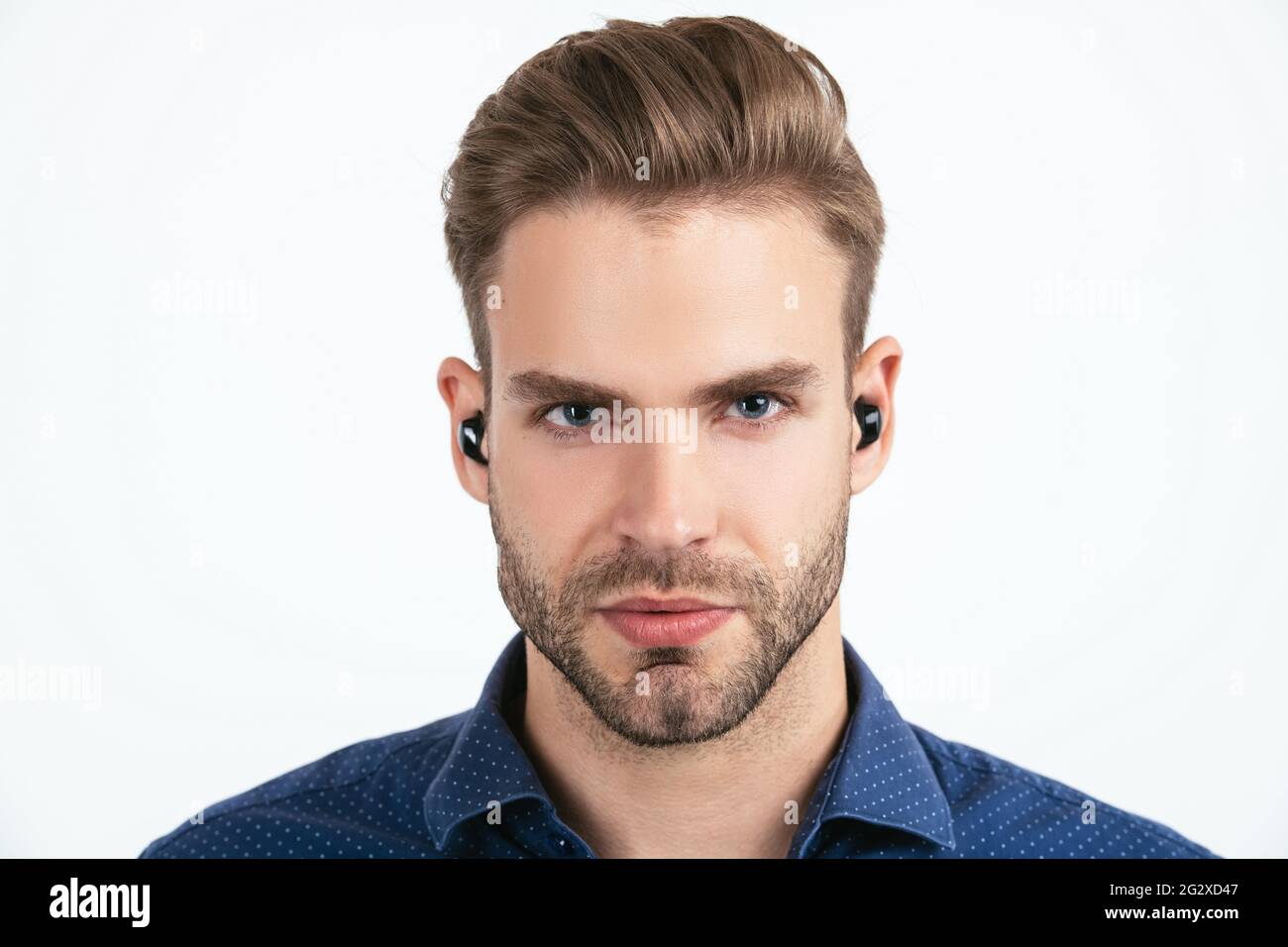 bell'uomo senza rasature con auricolari bluetooth wireless isolati su cuffie bluetooth bianche Foto Stock