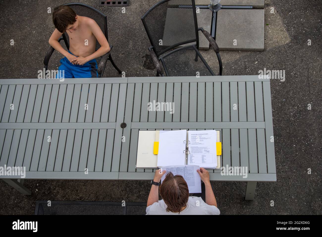 Una donna fa domande al figlio da un testo della scuola sulla religione prima di un esame. Foto Stock