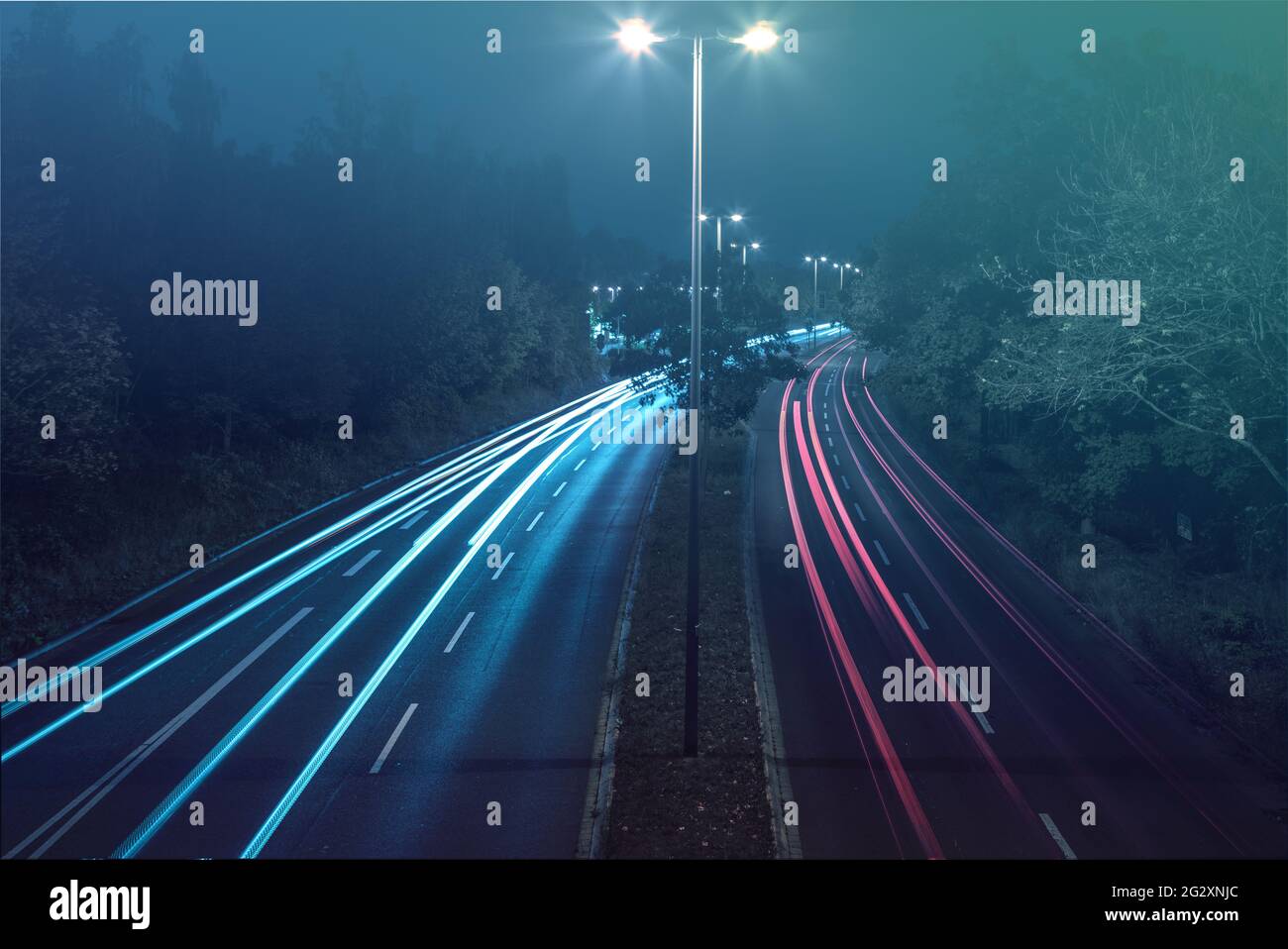 Foto a lunga esposizione di una strada a quattro corsie con luci luminescenti all'avvicinamento Foto Stock