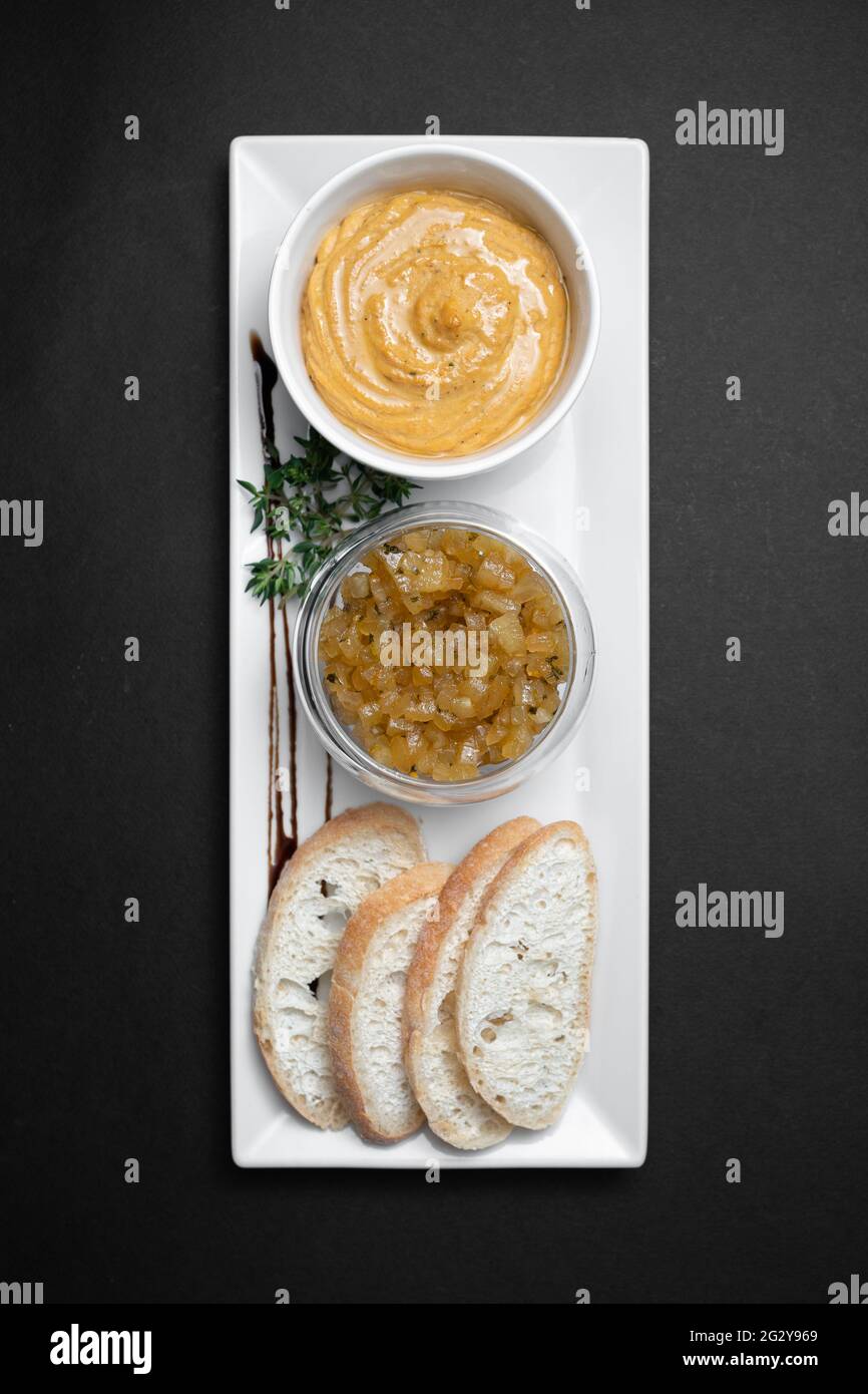 vista dall'alto del pate di fegato d'oca con chutneys di mele e pane su sfondo nero Foto Stock