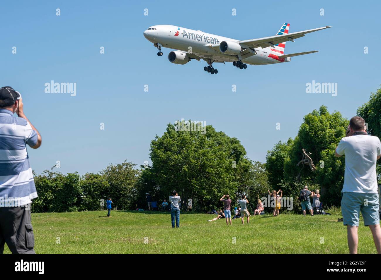 Aeroporto Heathrow di Londra, Londra, Regno Unito. 13 Giu 2021. Gli appassionati dell'aviazione si riuniscono in luoghi famosi intorno a Heathrow pronti a fotografare l'aereo "Air Force One" Boeing VC-25A (convertito nel 747 Jumbo Jet) che porta il presidente degli Stati Uniti Joe Biden dal G7 Summit di Newquay a Londra. I normali aerei atterrano su di loro. Il tempo è perfetto, con il cielo blu chiaro. American Airlines Boeing 777 sulle finali per atterrare in testa Foto Stock